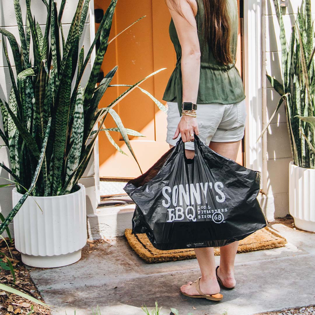 A delivery partner arrives with a Sonny's BBQ Bundle just in time for a 4th of July party.