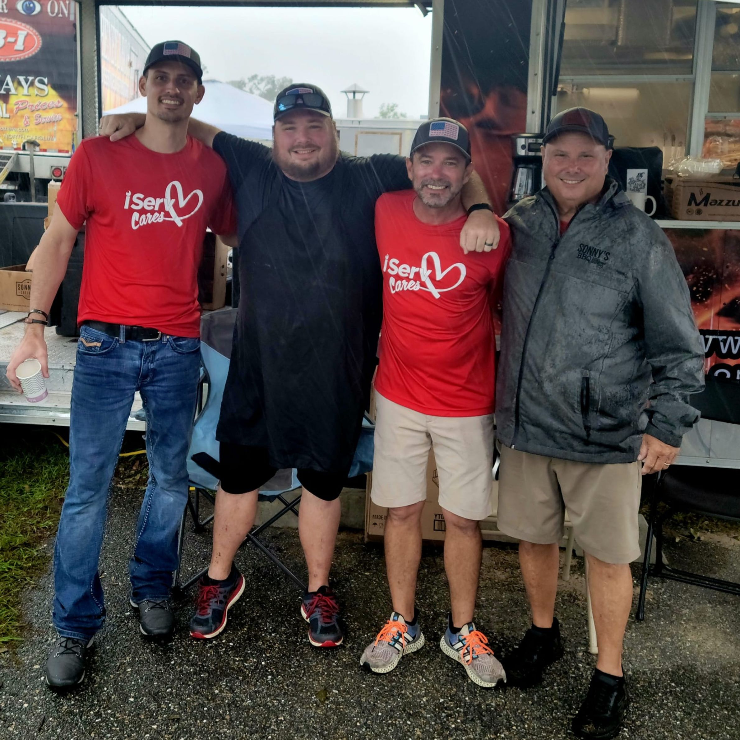 4 Members of the iServ Cares team smile as they cook up BBQ after Hurricane Idalia.