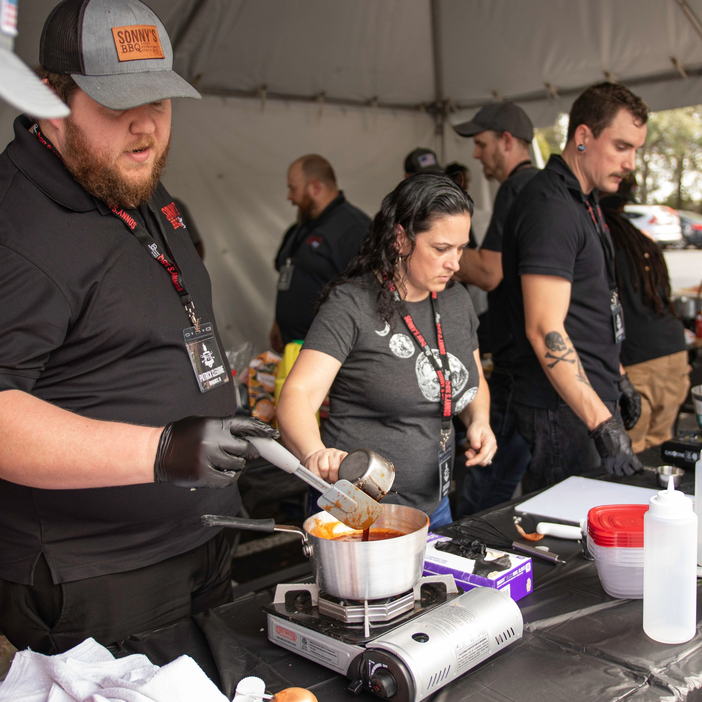 A group of Pit Academy students work together to create their own BBQ Sauces inside a tent.